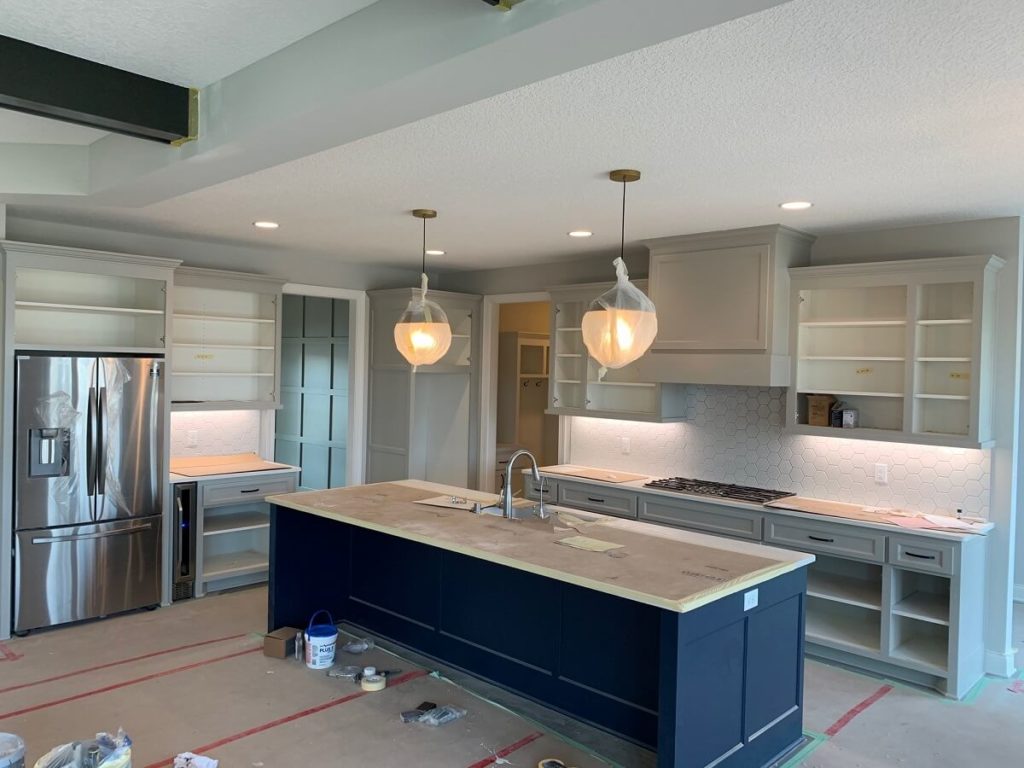 Kitchen with two tone cabinetry and navy blue island